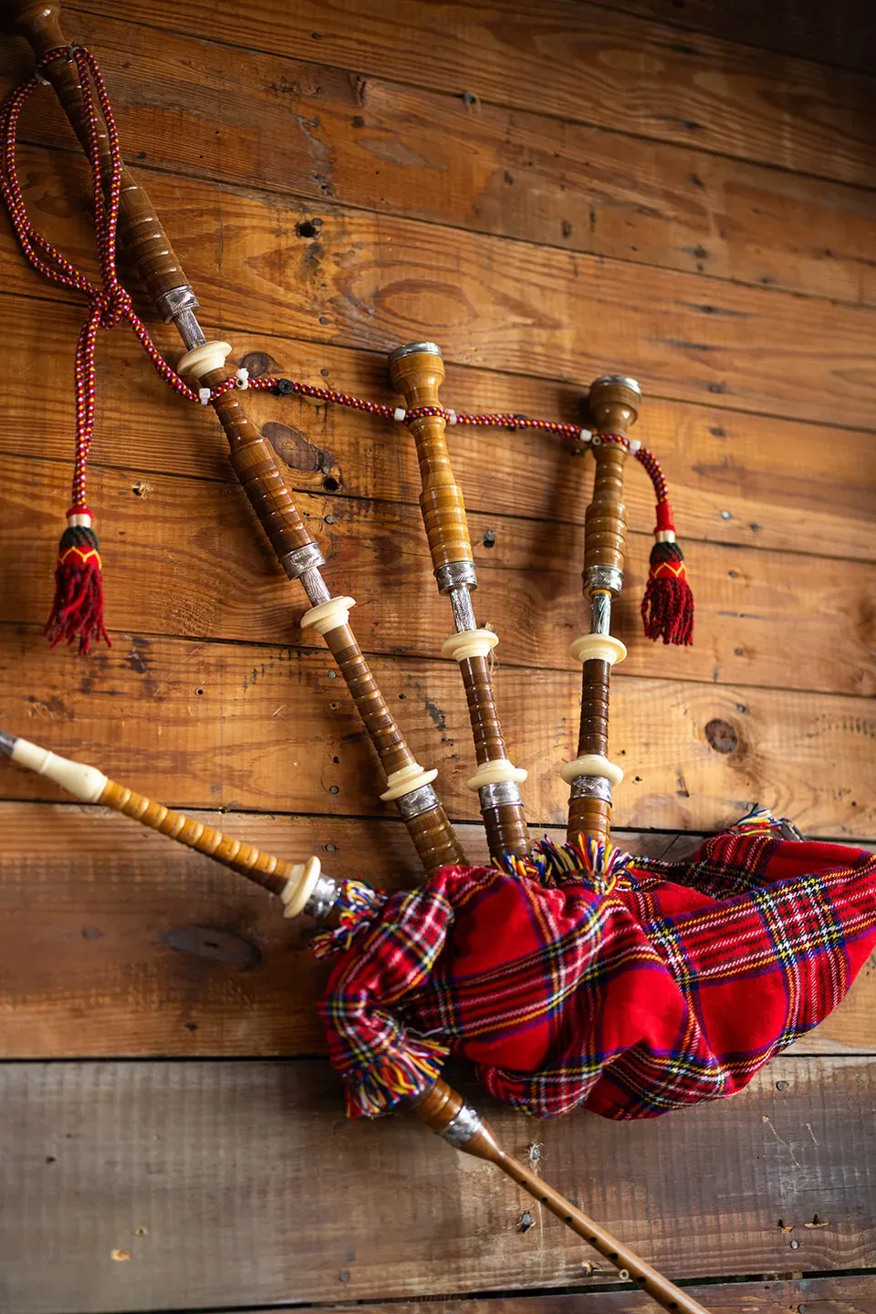 Bagpipes hanging on a wood-paneled wall