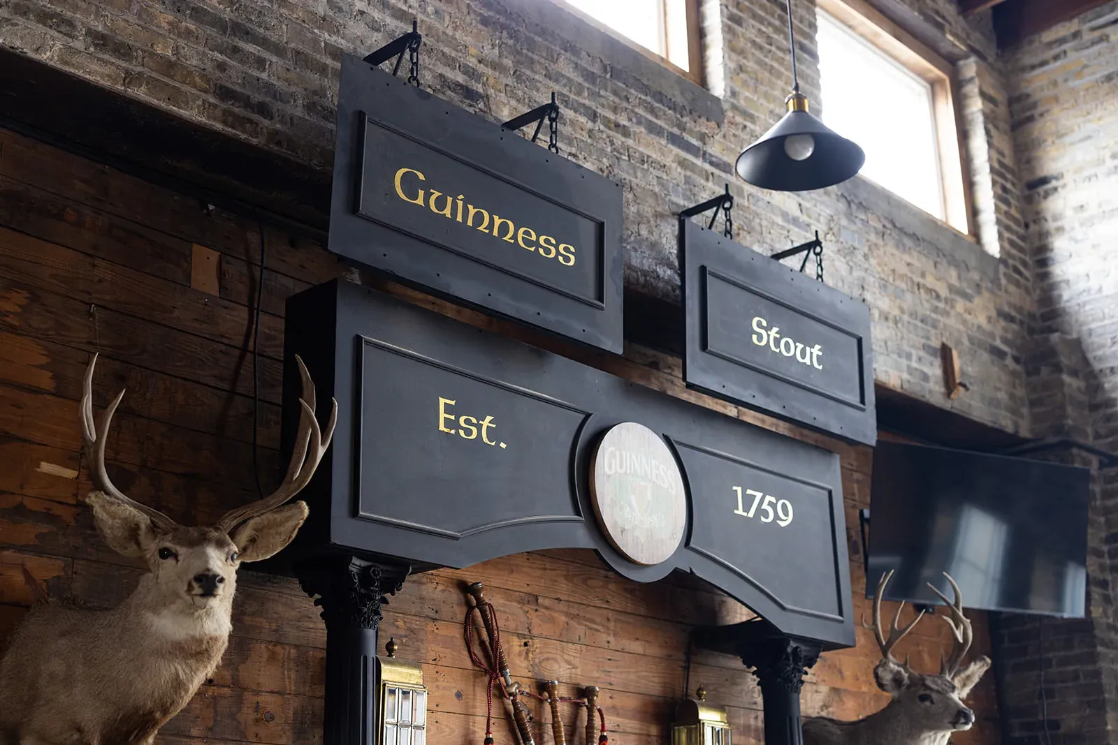 Rustic pub-style interior with Guinness signs and a mounted deer head